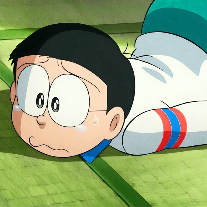 Nobita lười biếng nằm dài trên sàn nhà tatami xanh